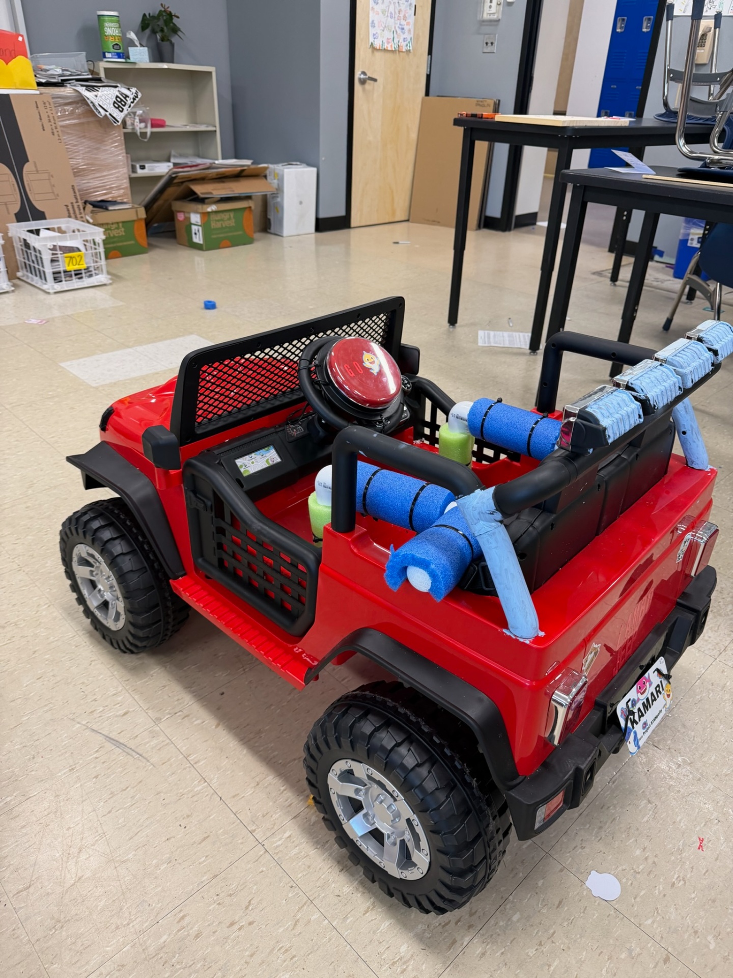 Close-up of a finished red adaptive Jeep with custom foam supports and a large yellow go-button