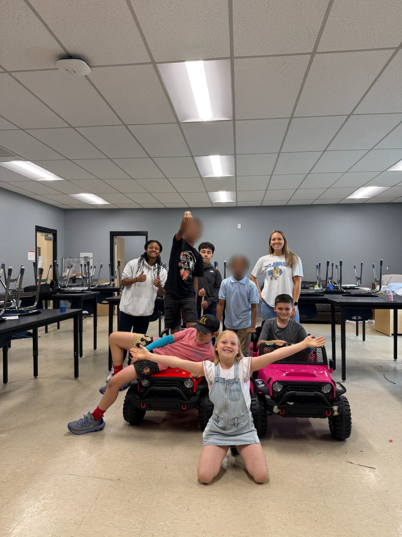 Students and mentors celebrating with finished ride-on cars